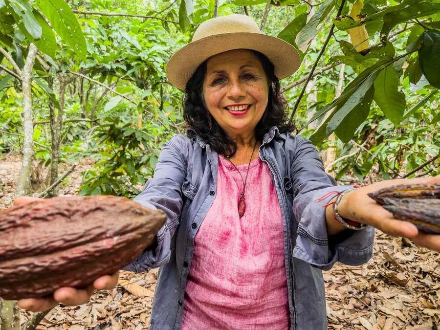 Rocío alegre sostiene dos cacaos en sus manos. Foto: WFP / María Beatriz Pertuz