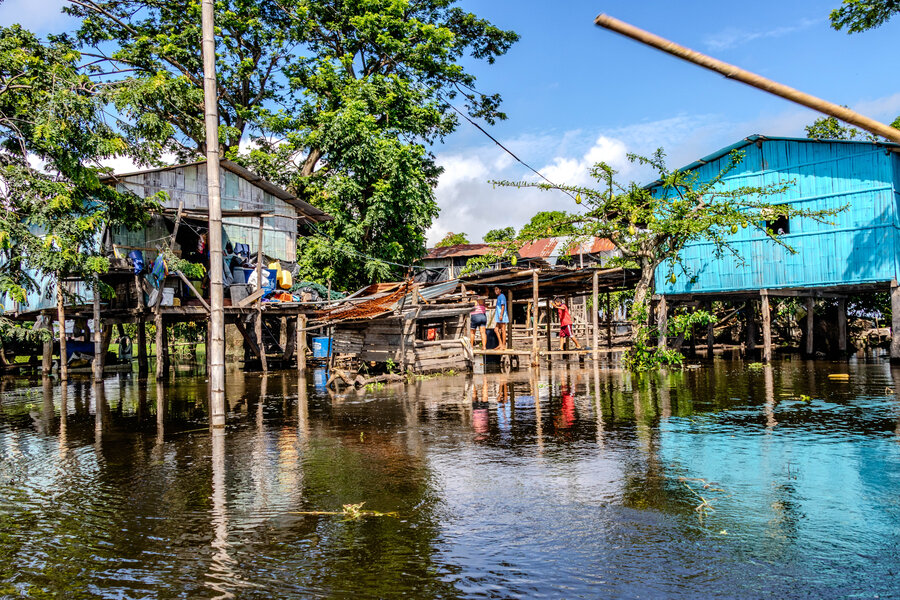 Dalinda Carranza, Angela Arteaga y Dilan Arteaga cruzan un puente improvisado de madera para atravesar las aguas de la inundación y llegar a su vivienda. La familia pertenece a la comunidad de Los Espinos, en el municipio de Samborondón. Foto : © WFP/Gonzalo Ruiz