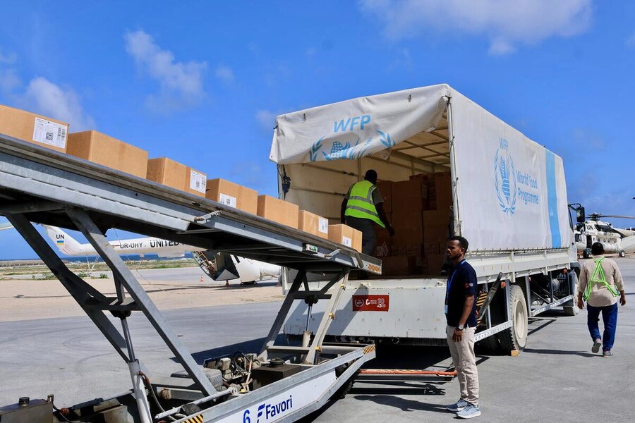 A line of WFP boxes sit on a belt in Mogadishu as a worker loads them into a WFP truck. Photo: WFP/CRC/Mohamed Ali