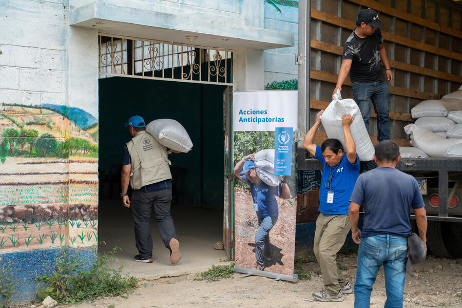 WFP employees load bags of grains into a warehouse that serves as a grain bank. Photo: WFP/Nelson Pacheco