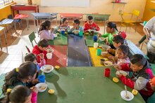 Niños y niñas se sientan a la mesa en un aula de clases para comer su comida escolar en una escuela en Ecuador. Foto: WFP/Esteban Barrera