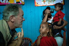 El Director Ejecutivo del WFP, David Beasley, y una niña de seis años se tocan la barbilla a la vez mientras juegan en una casa en Araya, Venezuela. 