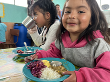 Una niña come su almuerzo preparado en la escuela en Ecuador.