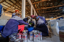 En un almacén de WFP en la República Democrática del Congo, un equipo logístico prepara paquetes de alimentos para distribuirlos entre las familias cuyos seres queridos se encuentran hospitalizados o aislados en centros de tratamiento del ébola en Beni.