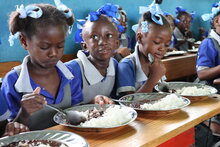 Photo: WFP/Alexis Masciarelli. students aged 5 to 7 eat a hot meal in their classroom in the primary school Baptiste Salem in Dondon, where 600 children are registered. Meals are preparing daily with rice and beans food purchased from local producers through WFP Home-Grown School Feeding programme. 