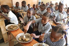 Estudiantes de primaria almuerzan en los pupitres de sus aulas en la escuela de la aldea de Belle Onde, en una zona árida y empobrecida del centro de Haití. Foto: WFP/Alexis Masciarelli