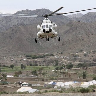 Helicóptero de UNHAS sobre volando un campo.