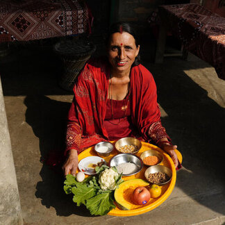Una mujer está enseñando los platos que ha preparado.