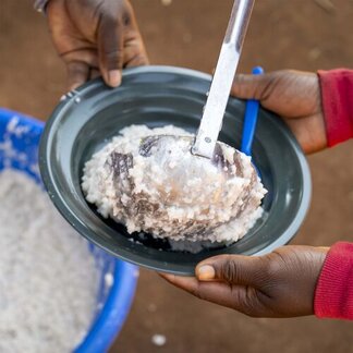 Chrissie y Livines sirven las comidas escolares a los alumnos de una de las escuelas apoyadas por WFP a través del programa de comidas escolares caseras. 