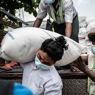 Ko Soe from an informal settlement in Hlaing Thar Yar township, Yangon brings home rice rations from WFP. Photo: WFP/Kaung Htet Linn