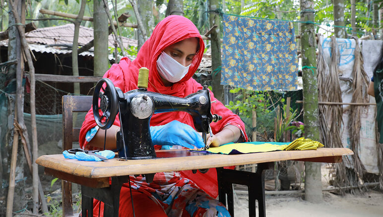 Durante la pandemia de la Covid-19, en Cox's Bazar, Bangladesh, el WFP trabajó con mujeres de la comunidad de acogida y refugiados rohingya a través de su programa de medios de vida para fabricar barbijos o mascarillas que fueron distribuidas por el gobierno local y las agencias humanitarias, otorgándoles un estipendio mensual, capacitación laboral comercializable y educación financiera y una beca para iniciar un negocio. WFP/Nalifa Mehelin